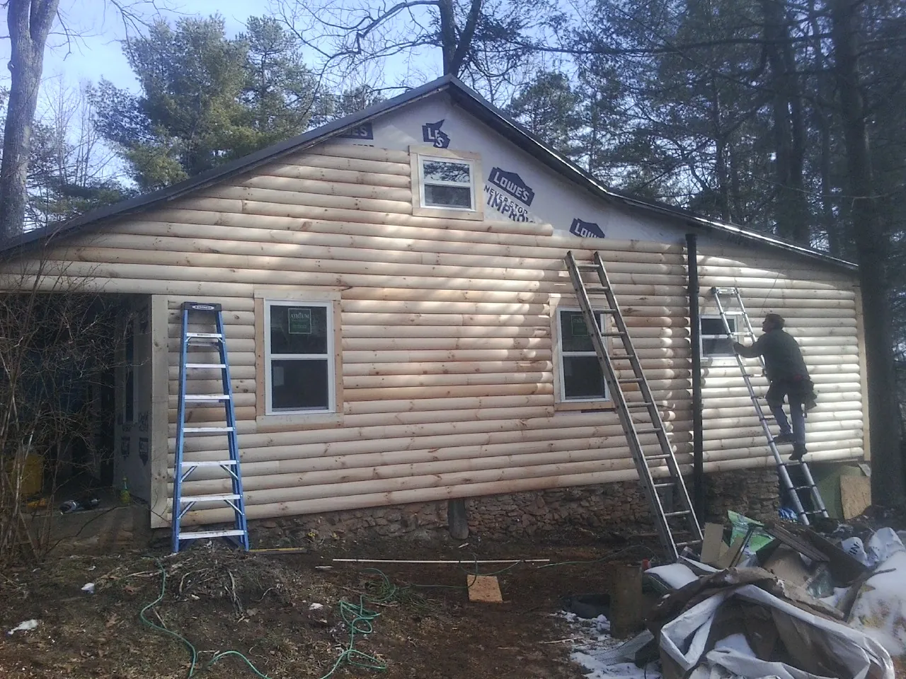 Ladders set against fresh log siding during an exterior remodel in Bethesda