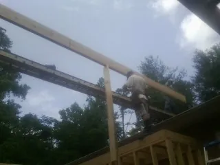 Carpenter setting a ridge beam over a new addition frame — Ice Dam Removal by Roofing Brothers in Bethesda