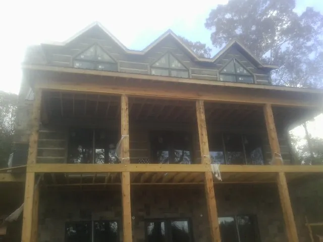 Dormers and porch framing on a large log home under construction — Roof Coating work by our crew in Bethesda