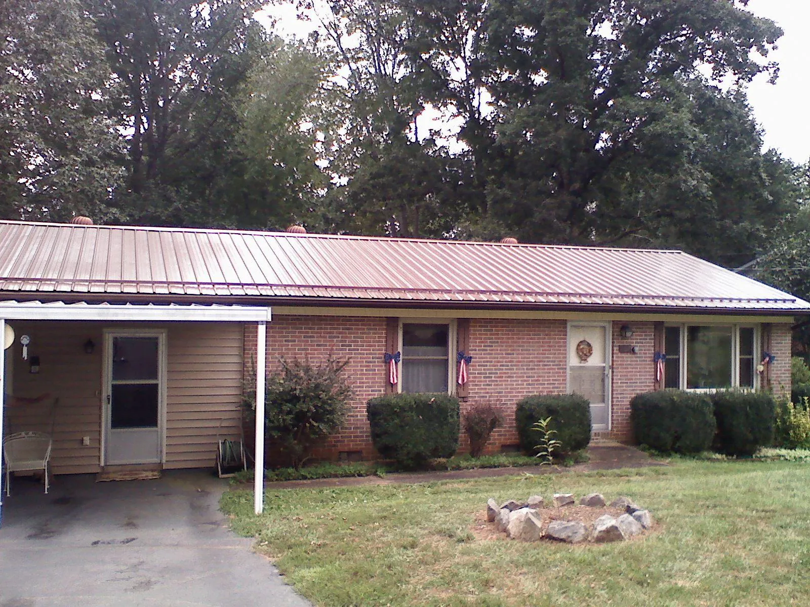 Bronze metal roof and carport on a brick ranch home — Roof Repair work by our crew in Bethesda